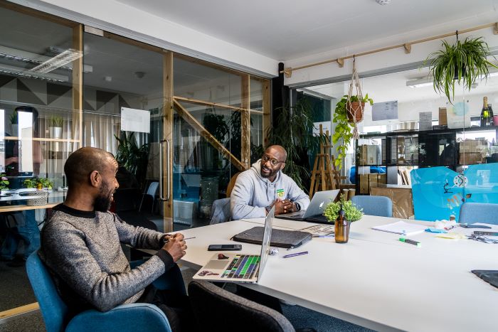 Two men in a modern work space with plants