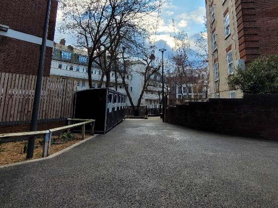 New smooth tarmac pathway through two building blocks on Margery Estate