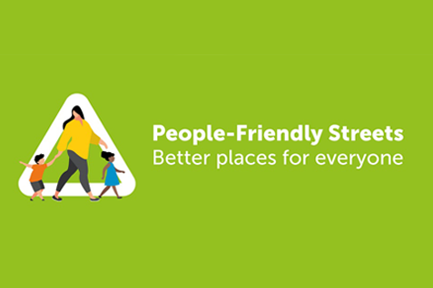 Illustration - lime green background, with a woman wearing a yellow jumper, and walking across the road with 2 young children. "People-Friendly Streets - Better places for everyone"