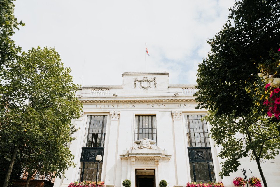 Islington Town Hall lit by bright sun with trees either side