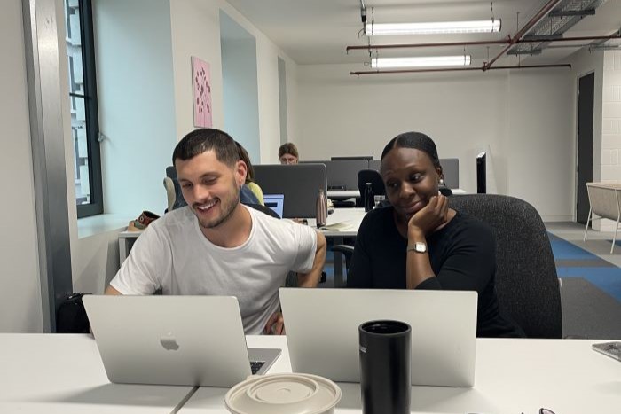 People working collaboratively at a desk in the Town Square Islington co-working space.