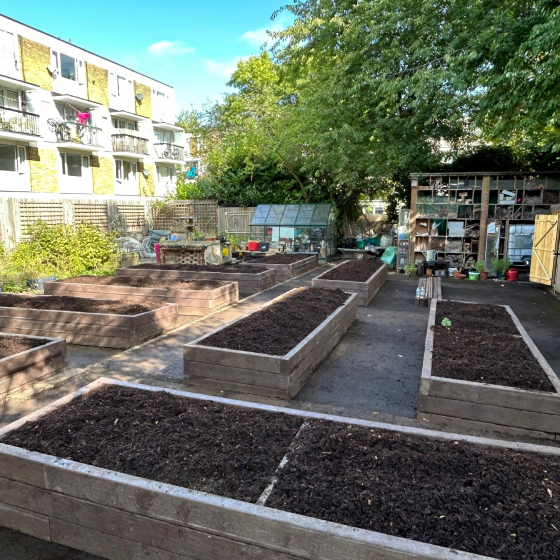 New wooden planters filled with soil in a communal garden.